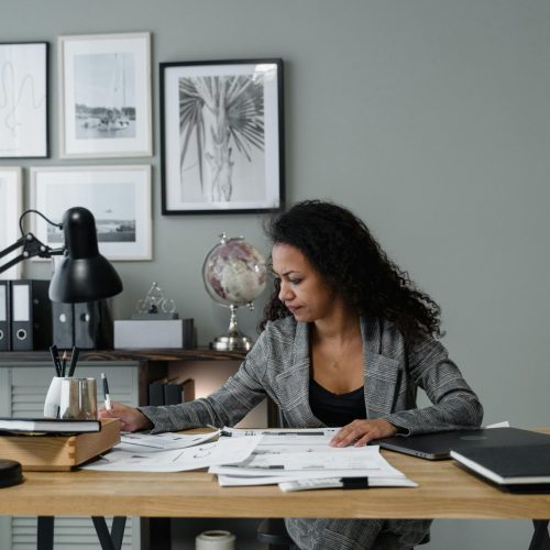 pexels-photo-6694529-6694529 Businesswoman evaluates documents at a modern desk in a stylish office setting.